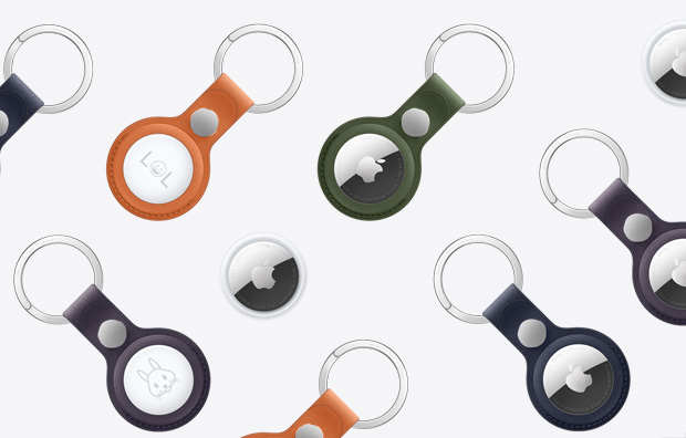 一组 AirTag，其中几个配有不同颜色的精织斜纹钥匙扣，配色包括橙色、暗绿色、深蓝色、黑莓色等。