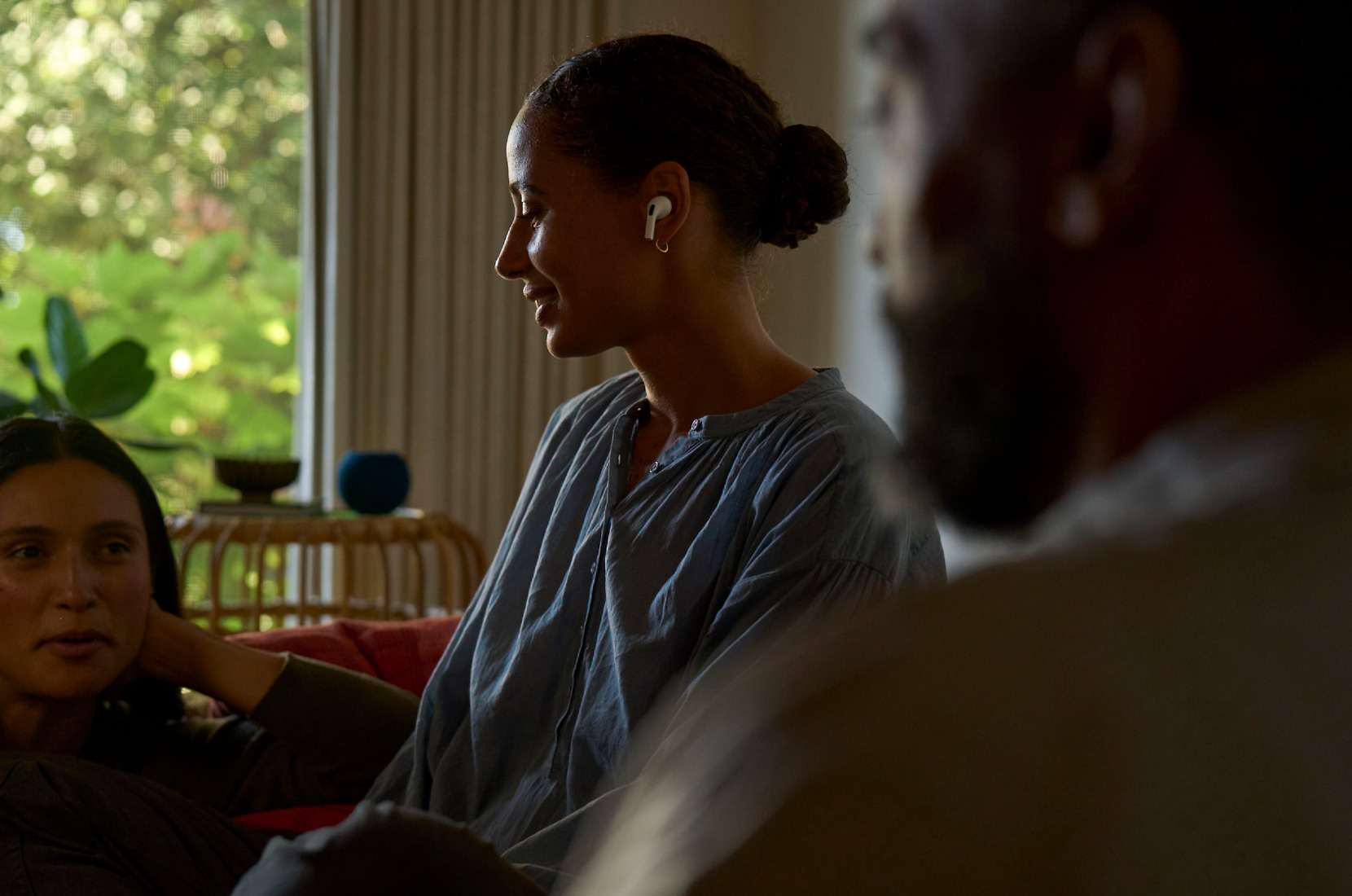 一位女士的侧面轮廓视图，展示她左耳戴着 AirPods Pro 2，正在使用听力呵护的功能。