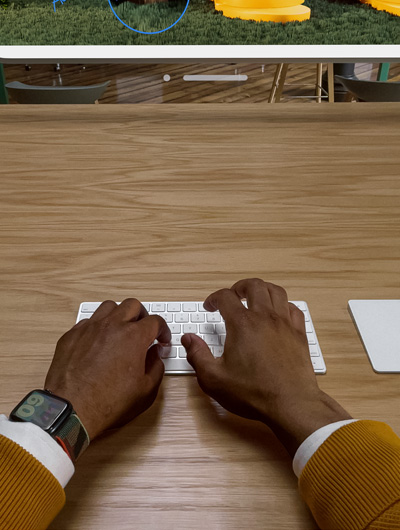 两只手放在妙控键盘上。