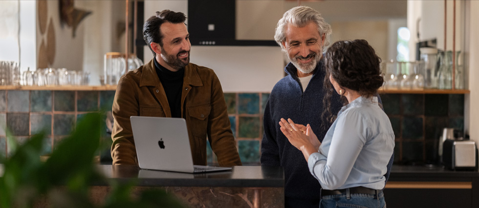 当一台 Macbook 放在桌子上时，两个男人和一个女人之间发生了对话。