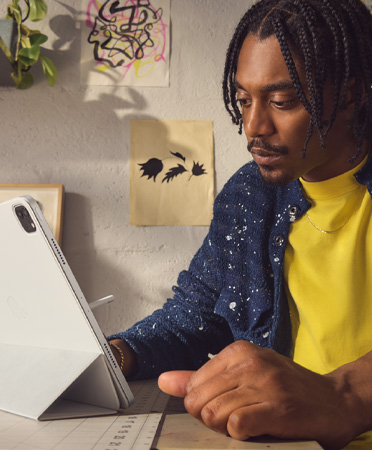 一个人借助智能双面夹，以适度的观看距离使用 iPad Air。