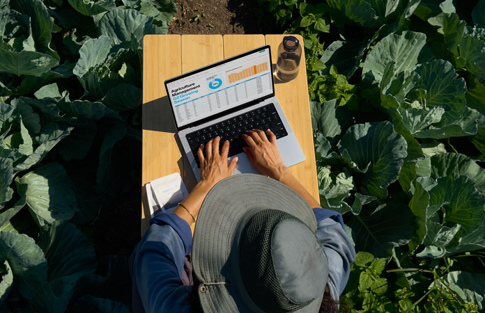 一个人在室外使用选配纳米纹理显示屏的 MacBook Pro，展示屏幕减少眩光的特性。