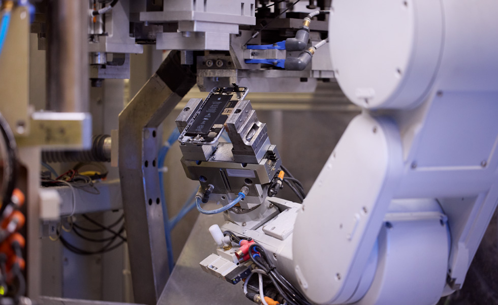 拆解机器人 Daisy 举着 iPhone 的零部件