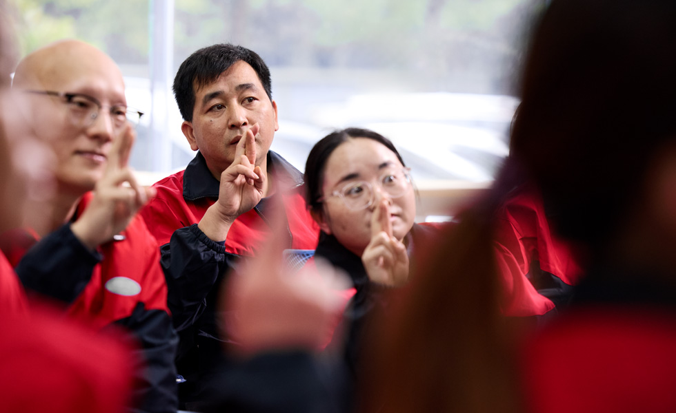 几个人望着同一个方向，做着同样的手势